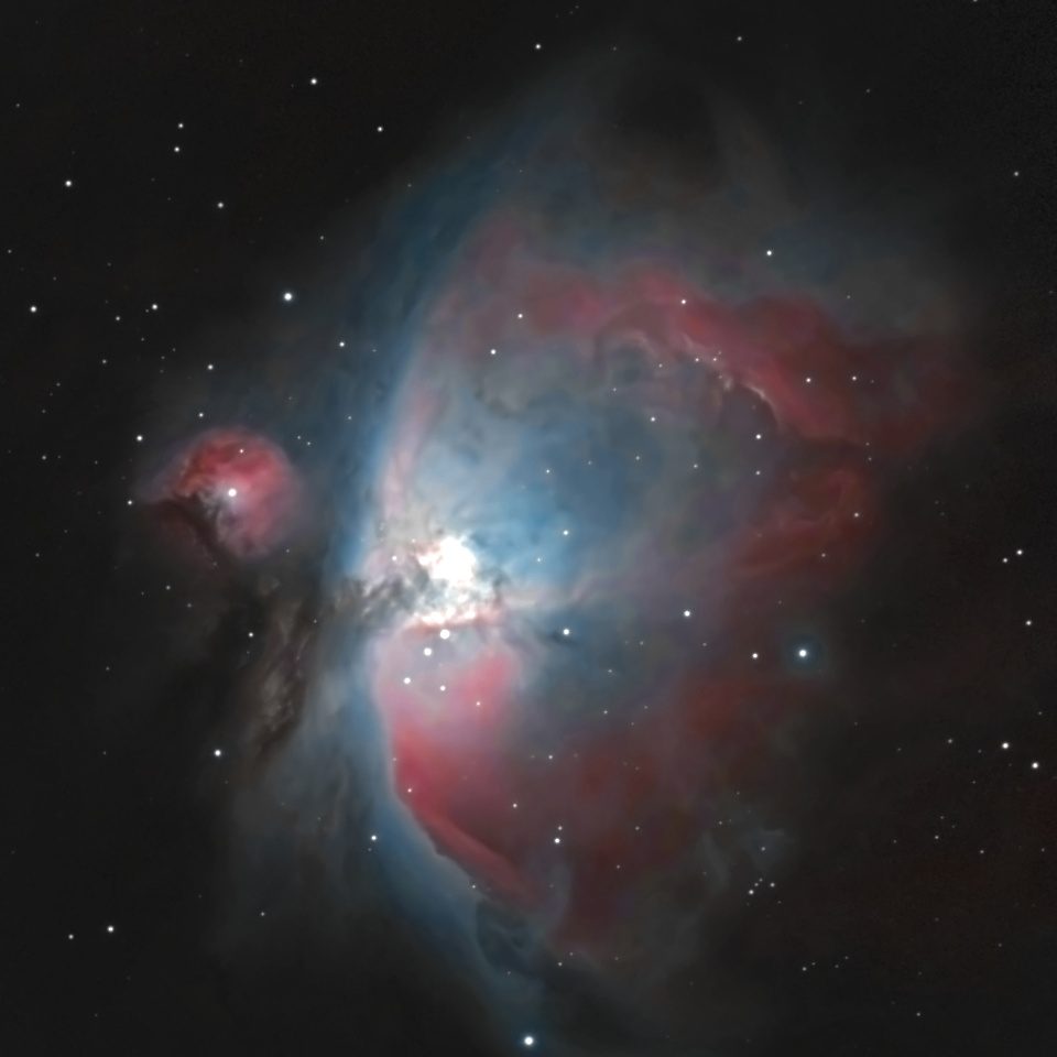 The Orion Nebula (M42) photographed from Lakeway, Texas with a ZWO Seestar S50 — pink hydrogen wings and a blue interior glow around the bright Trapezium core, with the dark Fish’s Mouth dust lane and companion nebula M43.