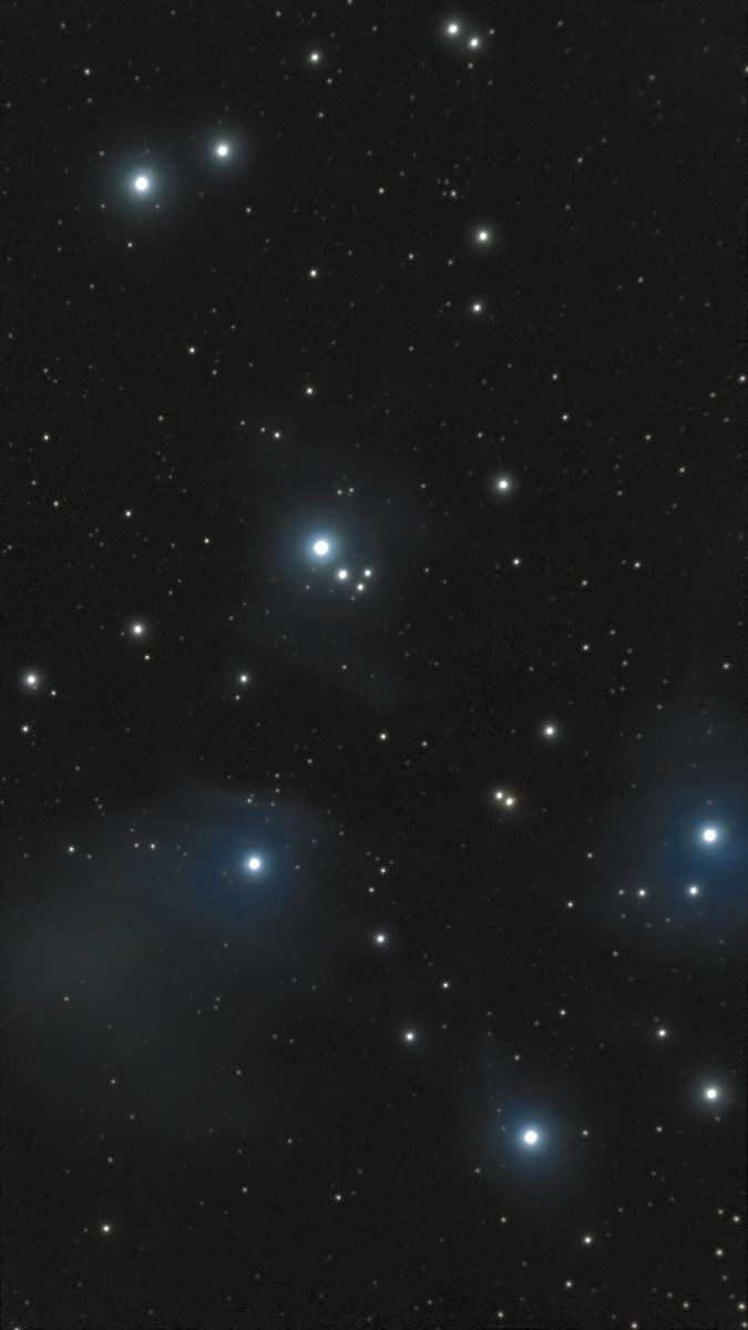 The Pleiades (M45) photographed from Lakeway, Texas with a ZWO Seestar S50 — a cluster of brilliant blue-white stars wrapped in wisps of blue reflection nebulosity, against a dark sky.