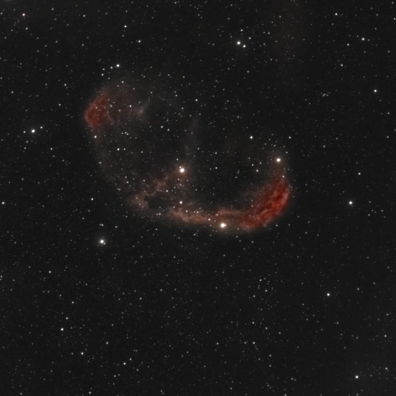 The Crescent Nebula (NGC 6888) photographed from Lakeway, Texas with a ZWO Seestar S50 — a red-rimmed crescent-shaped shell of gas with mottled interior filaments, floating in a dense Cygnus star field with the central Wolf-Rayet star visible.