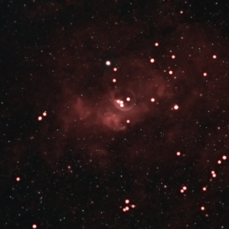 The Bubble Nebula (NGC 7635) photographed from Lakeway, Texas with a ZWO Seestar S50: a faint red shell of glowing hydrogen around a bright central star, embedded in a larger patch of red nebulosity in a dense star field.